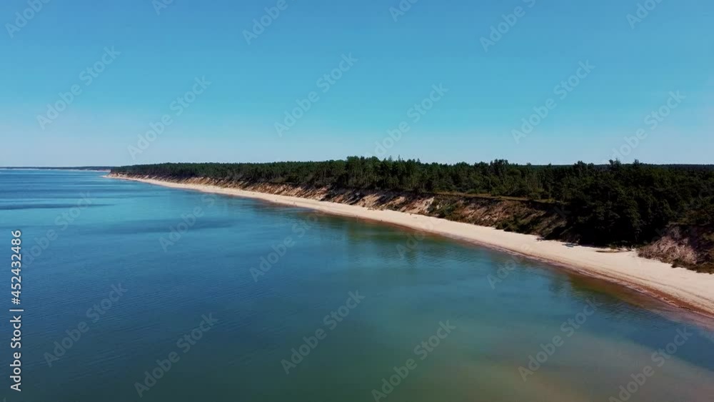 Flying Over Coastline Baltic Sea Jurkalne Seashore Bluffs Near Pavilosta Latvia and Landslides With an Overgrown, Rippling Cave Dotted Cliff and Pebbles. Aerial Dron View. Camera Moves Forward Flying Over Coastline Baltic Sea Jurkalne Seashore Bluffs Near Pavilosta Latvia and Landslides With an Overgrown, Rippling Cave Dotted Cliff and Pebbles. Aerial Dron View. Camera Moves Forward