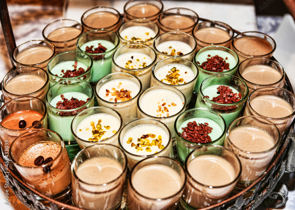 Many dessert glasses filled with coffee cream and white cream
