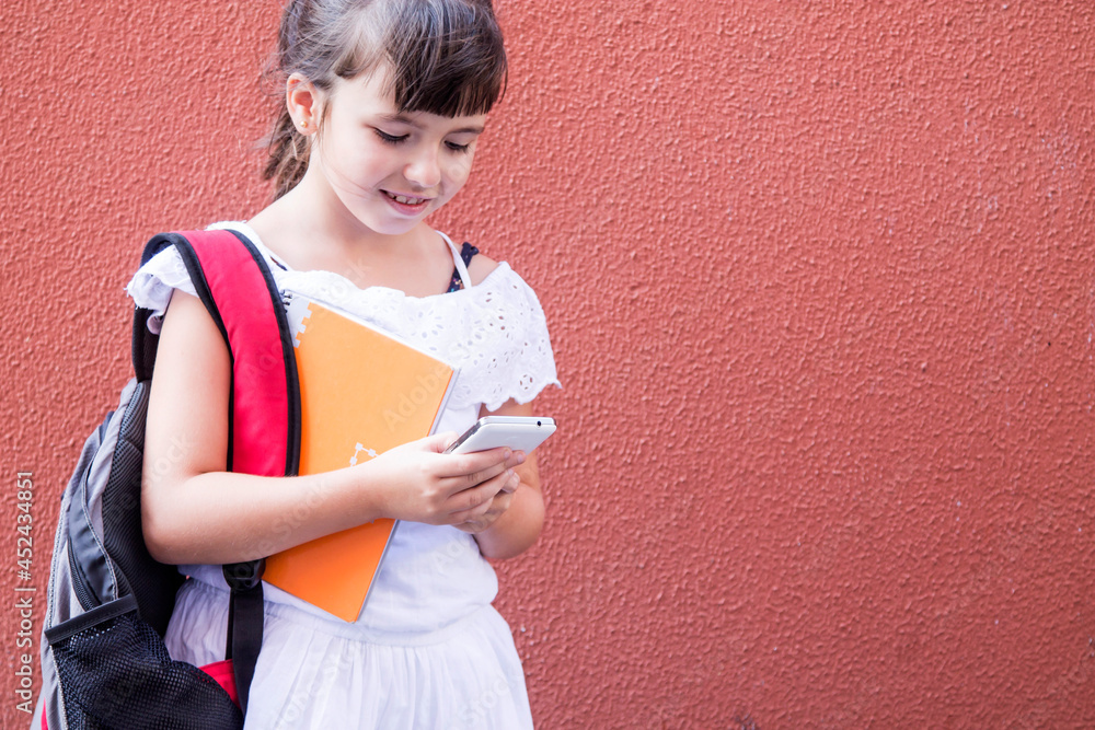 student girl with backpack and notebook using mobile phone student girl with backpack and notebook using mobile phone