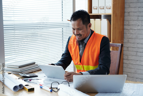 Head contractor with tablet computer making video call to discussing project details with contrition engineer and architect photo