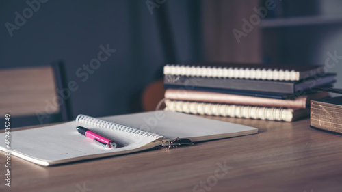 Desk for student education concept. Book for study for exam. Stack of book, diary and pen placed on white School table in the living room for student plan to work at home.