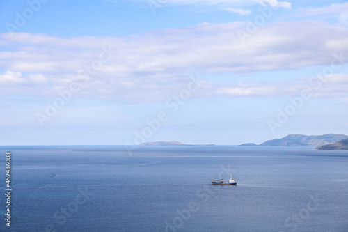 Sea background with Fishing boat sailing under blue sky © Gatot
