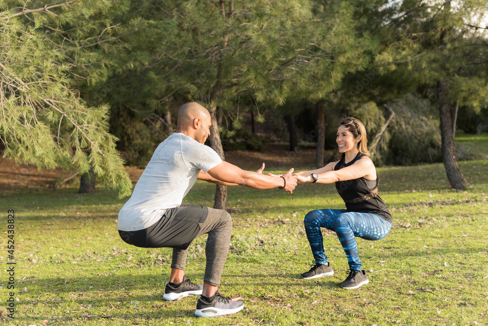 Fitness couple exercising by holding hands in the park Fitness couple exercising by holding hands in the park