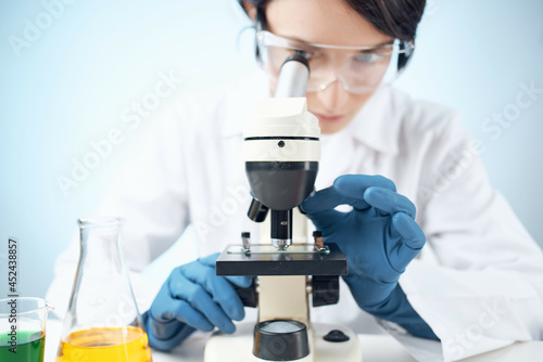 woman in laboratory looking through microscope close-up biotechnology science