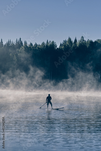 Man on paddle board surfing wild mountain river