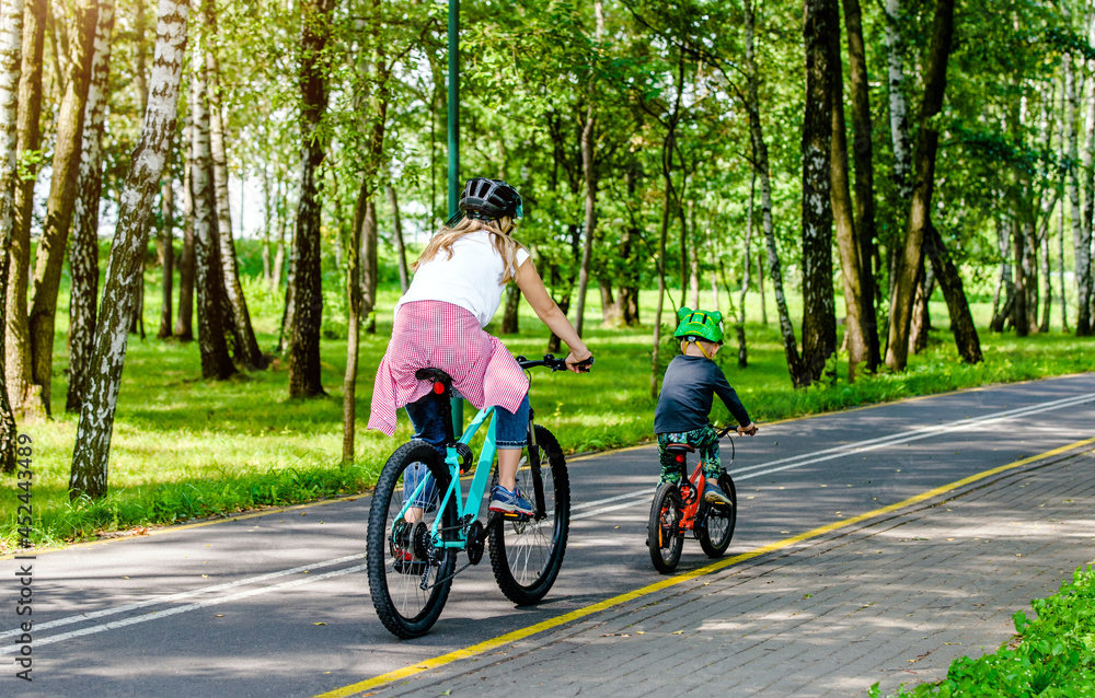 A woman and her son ride bicycles in the park