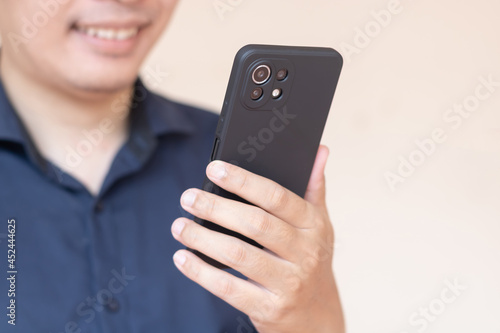 Wallpaper Mural Happy Asian man smile and using or holding smartphone with one hand. Torontodigital.ca