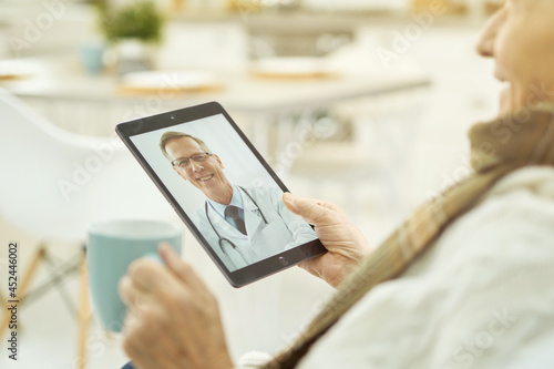 Advanced pensioner using tablet to communicate with doctor