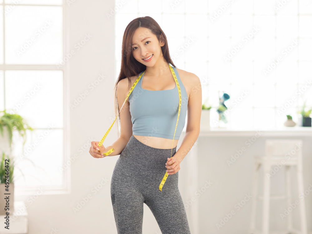 Slim Young woman and measure tape around her body Slim Young woman and measure tape around her body