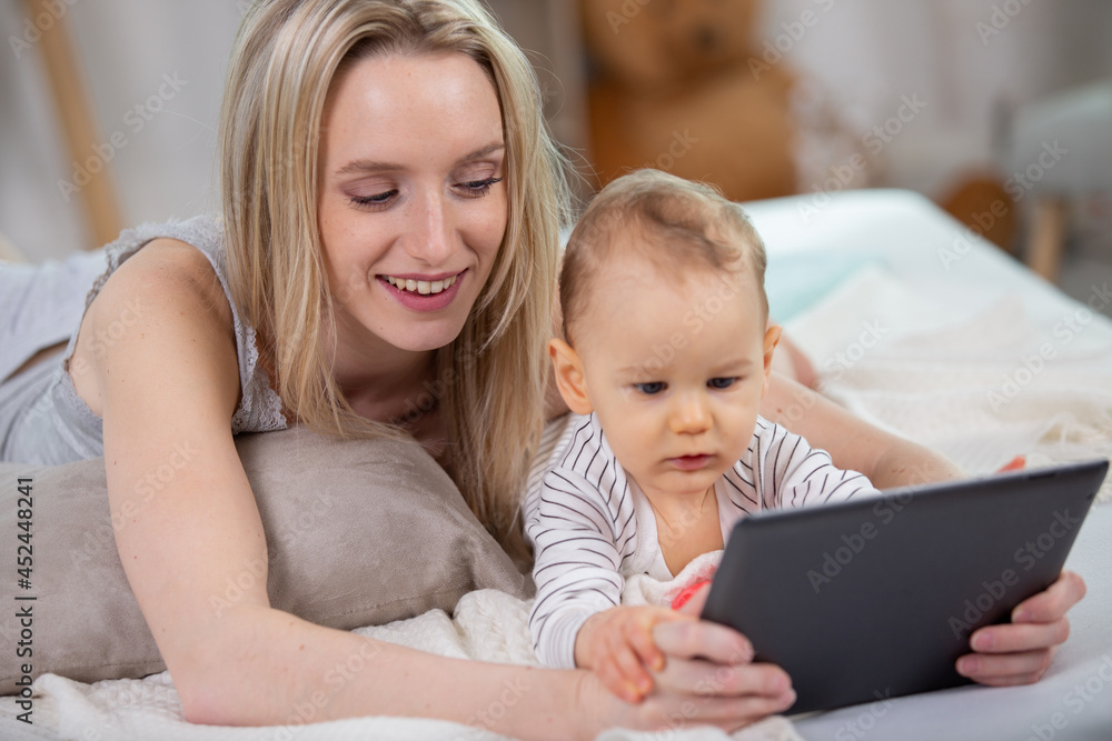 mother and baby are looking to play tablet computer mother and baby are looking to play tablet computer