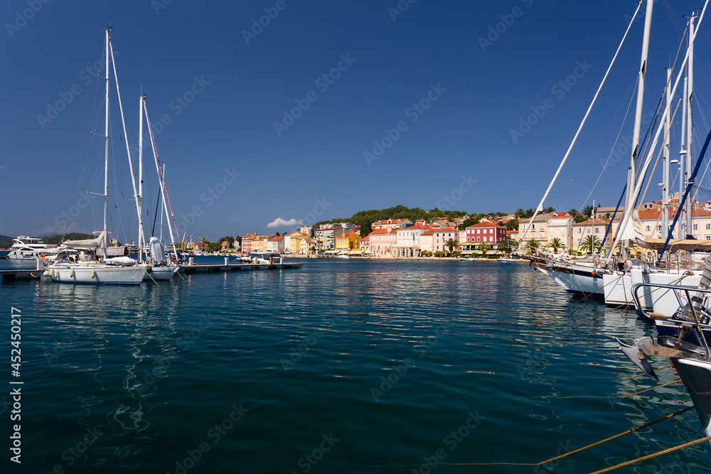 yachts moored at the wooden pier in harbour of Losinj town, Croatia.
