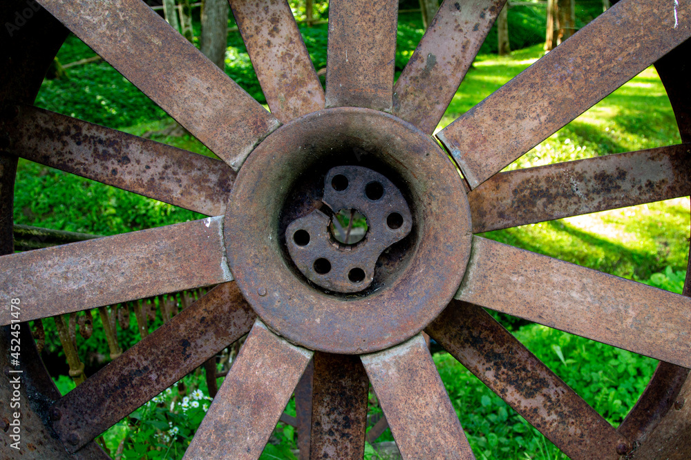 Old parts of mechanisms in the forest. Rusty wheels and parts in the grass Old parts of mechanisms in the forest. Rusty wheels and parts in the grass