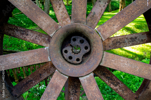 Old parts of mechanisms in the forest. Rusty wheels and parts in the grass