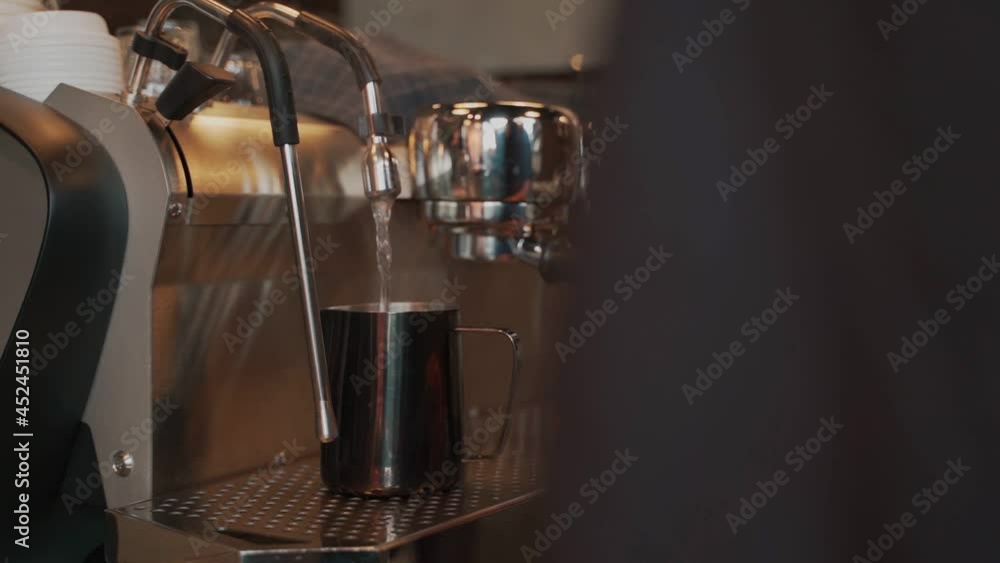 boiling hot water pouring from automatic boiler of espresso coffee machine. barista prepare hot water with steam before making coffee. boiling hot water pouring from automatic boiler of espresso coffee machine. barista prepare hot water with steam before making coffee.