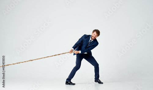 a man in a suit pulling a rope office manager teamwork photo