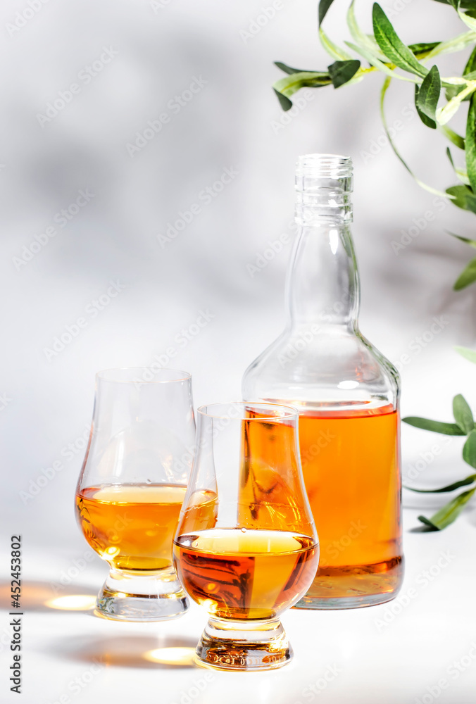 Scotch Whiskey in special glasses and bottle, white background with negative space Scotch Whiskey in special glasses and bottle, white background with negative space