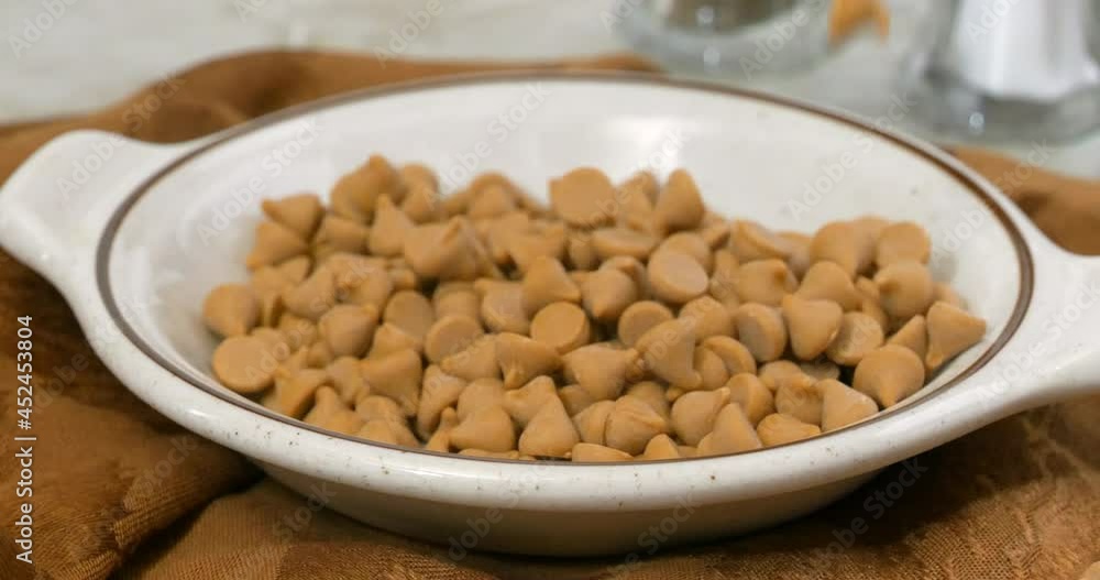 Butterscotch morsels falling into a small bowl slow motion
Butterscotch morsels falling into a small bowl slow motion