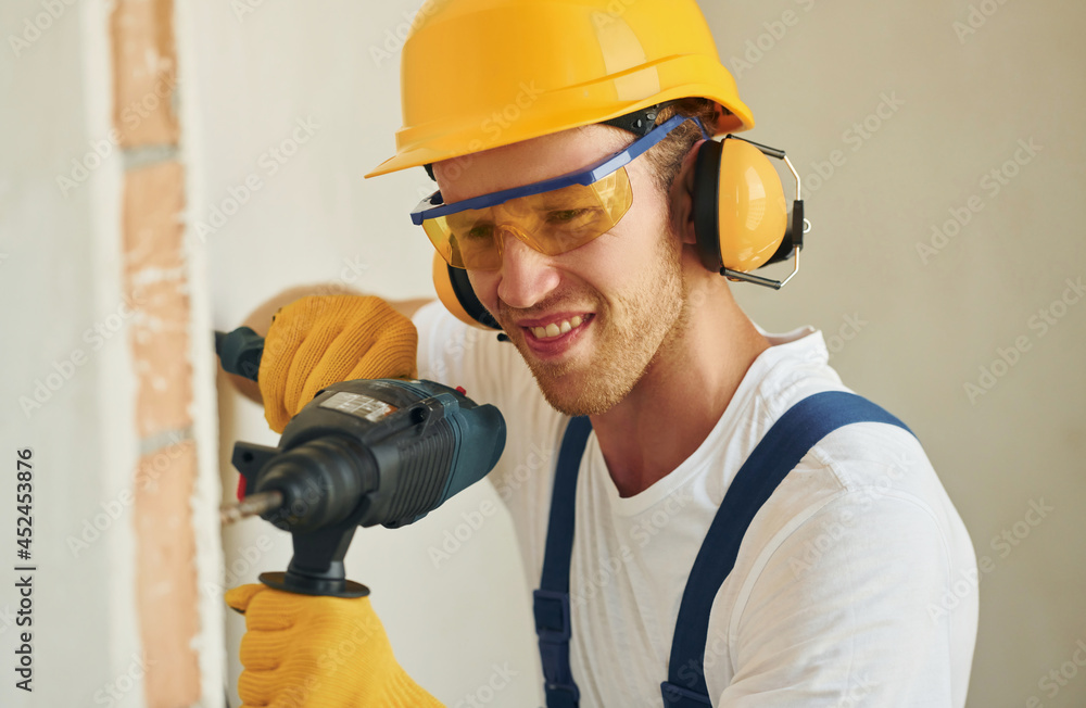 Portrait of young man working in uniform at construction at daytime Portrait of young man working in uniform at construction at daytime