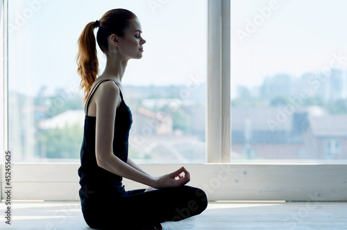 Free Download woman sitting in lotus position meditation rest near window - GFXLoad