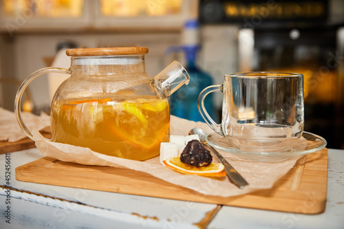 Sea buckthorn tea in a transparent glass teapot. Close-up, selective focus