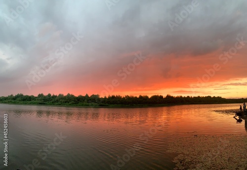 Panoramic view of the river at sunset time. There are boats near the shore.