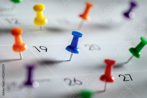 Calendar appointment thumbtacks in various dates on calendar diary