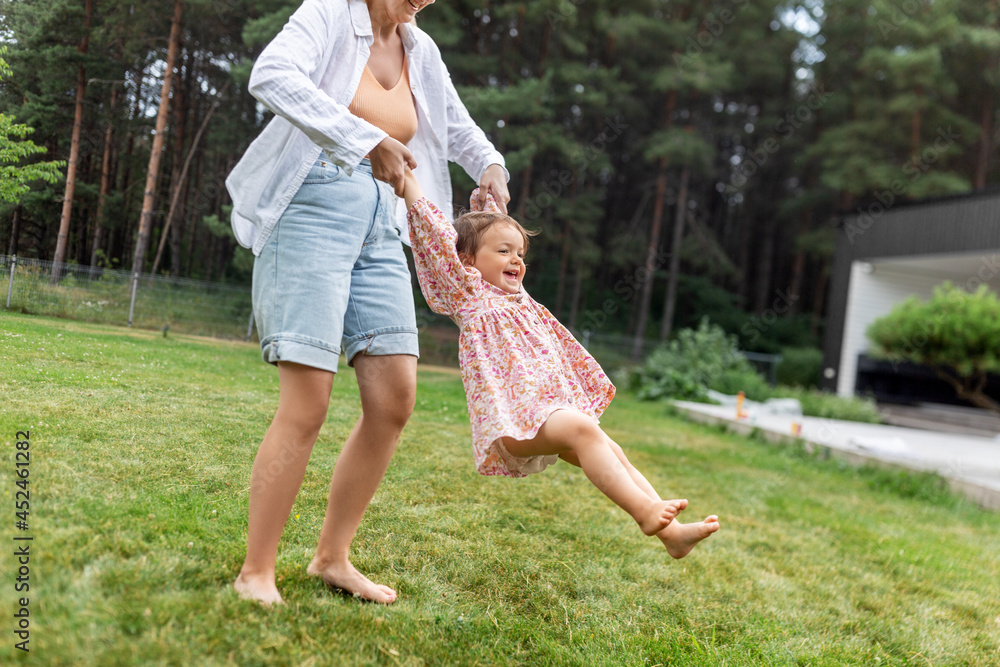 Fototapeta premium family, motherhood and people concept - happy smiling mother playing with little baby daughter outdoors
