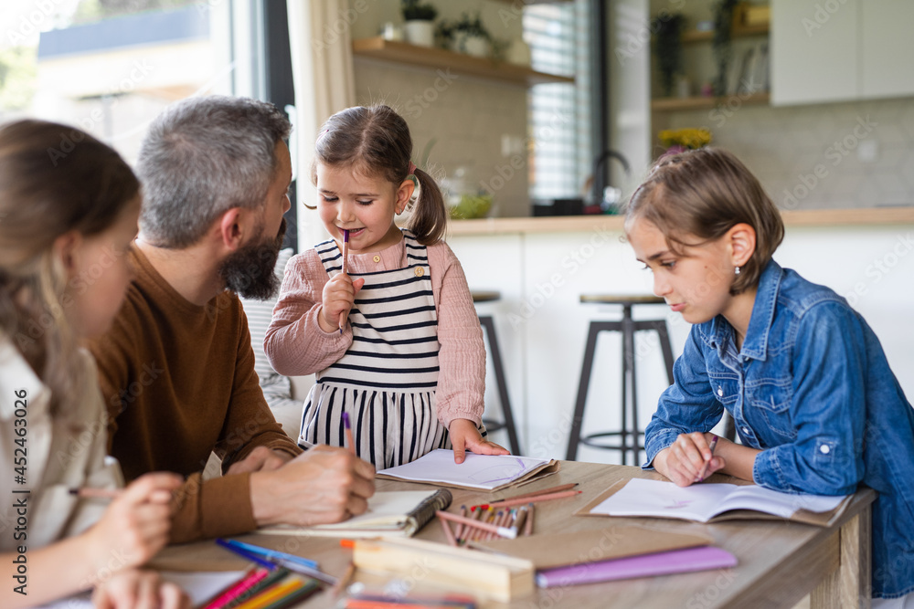 Father with three daughters indoors at home, drawing pictures. Father with three daughters indoors at home, drawing pictures.