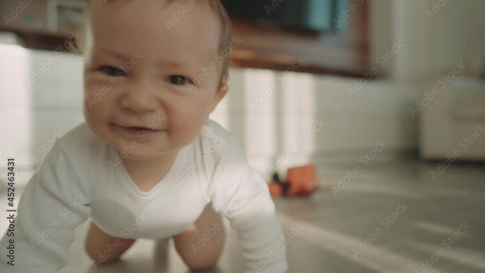 Cute happy little toddler baby boy is crawling on a wooden floor at home. Concept: life, childhood, first year of life, parenthood, home. High quality 4k footage Cute happy little toddler baby boy is crawling on a wooden floor at home. Concept: life, childhood, first year of life, parenthood, home. High quality 4k footage