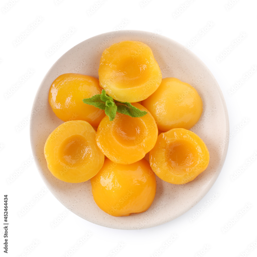 Halves of canned peaches with mint leaves isolated on white, top view Halves of canned peaches with mint leaves isolated on white, top view