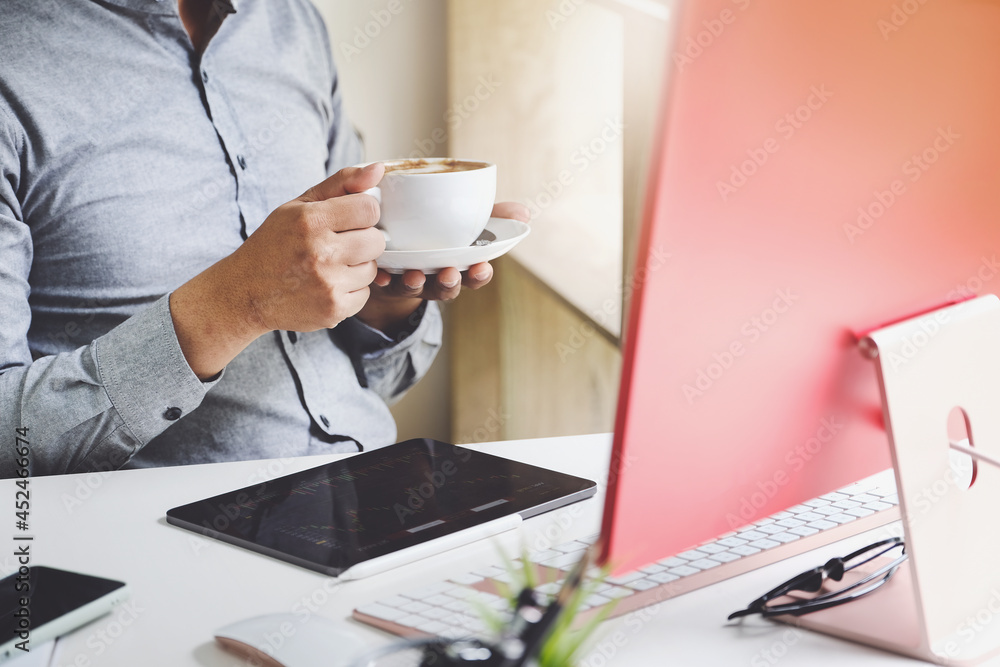 Work from home A company employee holding a coffee cup using tablet and computer to work from home to prevent coronavirus from meeting outsiders. Work from home A company employee holding a coffee cup using tablet and computer to work from home to prevent coronavirus from meeting outsiders.