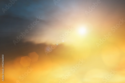 Natural background blurring warm colors and bright sun light. Sky sunny color orange light patterns plain abstract flare evening clouds blur.