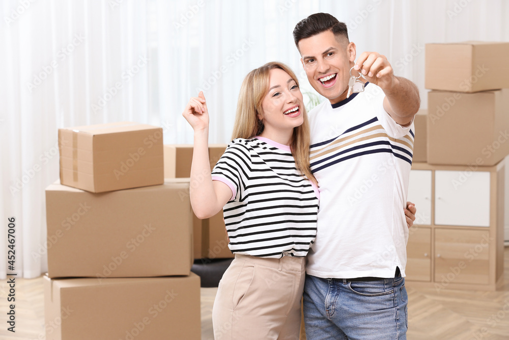 Happy couple with key from their new house indoors Happy couple with key from their new house indoors