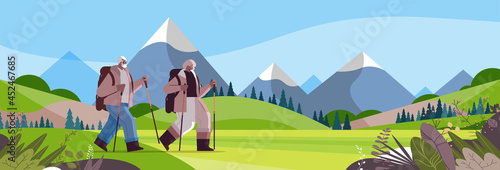 senior african american man woman hikers traveling together with backpacks active old age physical activities