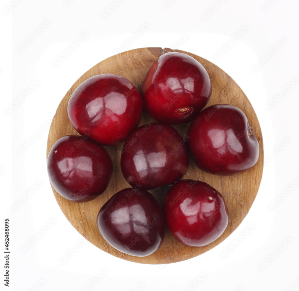 Cherry fruits in wooden cup isolated on white background. Top view Cherry fruits in wooden cup isolated on white background. Top view