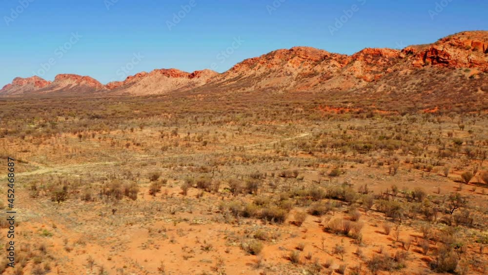 Road Amidst The Wilderness And Rugged Mountain Ranges At West MacDonnell National Park In Australia. aerial Road Amidst The Wilderness And Rugged Mountain Ranges At West MacDonnell National Park In Australia. aerial