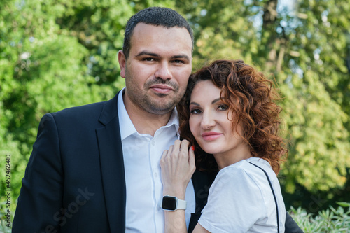 Portrait of a couple in love. A Middle Eastern man in a business suit with his curly-haired wife in a black dress © Galina