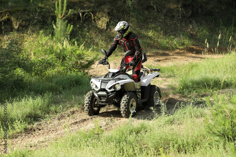 Man driving modern quad bike on sandy road. Extreme sport Man driving modern quad bike on sandy road. Extreme sport