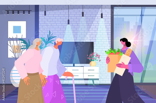 friendly nurse or volunteer bringing food to senior couple home care services healthcare and social support concept