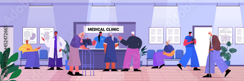 senior patients visiting medical clinic office female receptionist giving information for old people at reception desk
