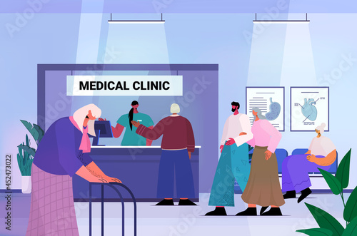 senior patients visiting medical clinic office female receptionist giving information for old people at reception desk