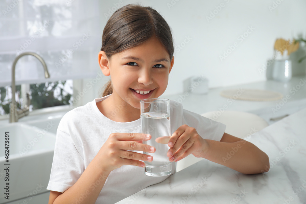 Girl drinking tap water from glass in kitchen Girl drinking tap water from glass in kitchen
