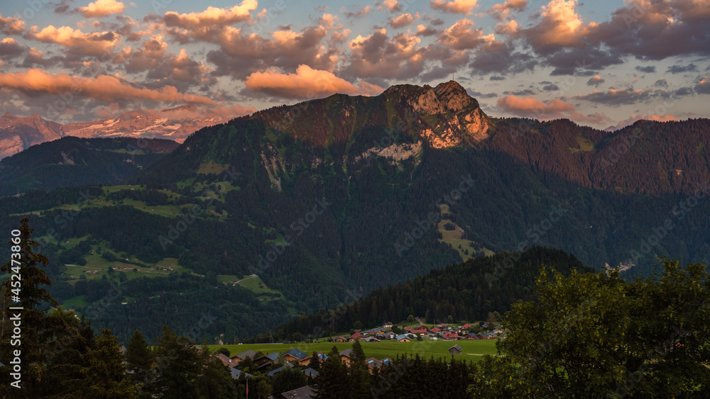 Spectacular Alpine view of a sunset with orange clouds over the Alps near swiss municipality of Leysin near Aigle in the canton of Vaud - Switzerland in summer