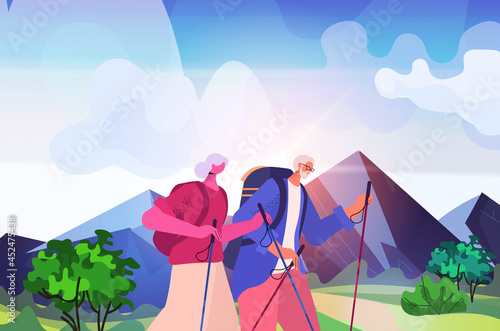 senior man woman hikers traveling together with backpacks active old age physical activities concept landscape