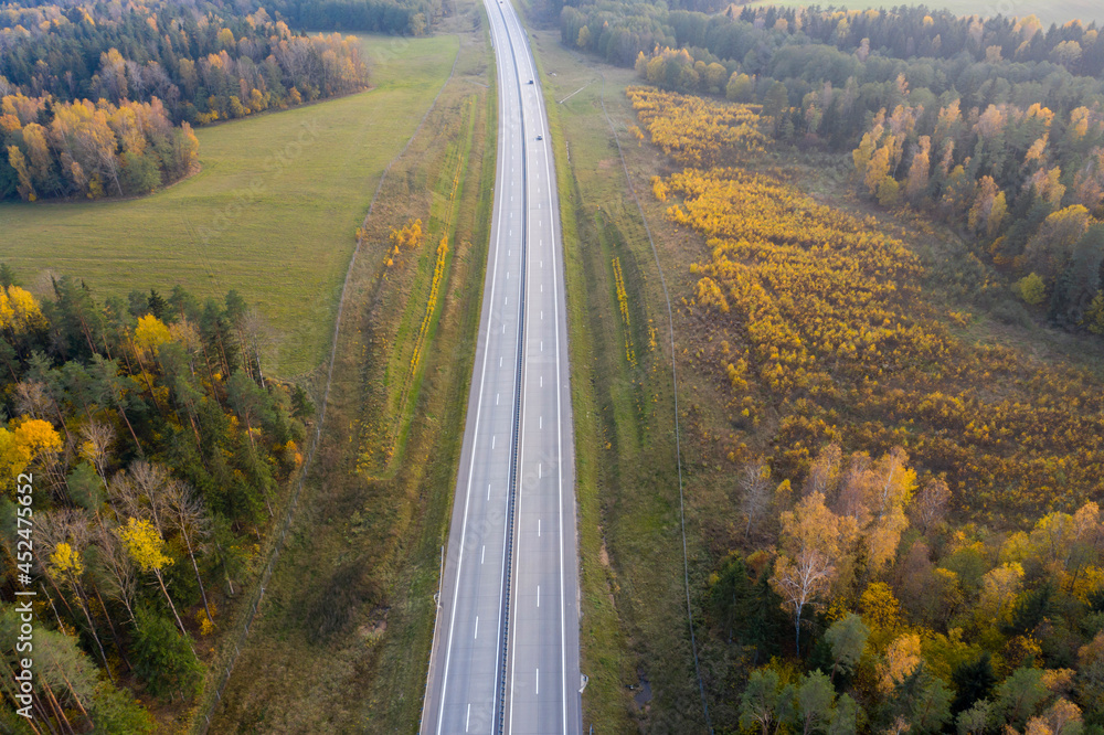 Aerial view of freeway road in autumn forest.