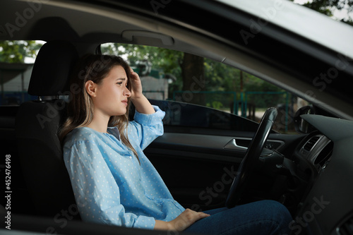 Stressed young woman in driver's seat of modern car © New Africa