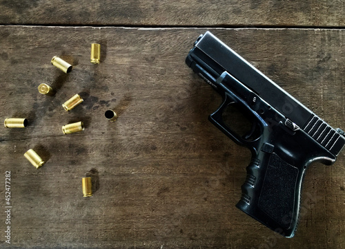 Slika na platnu Empty bullets and a gun on at table