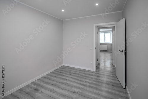 Apartment after renovation. Modern interior of empty room. White walls. Opened door. Black and white.