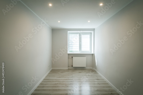 Contemporary apartment. Light interior of renovated room. Parquet floor. Window on wall. Nobody.