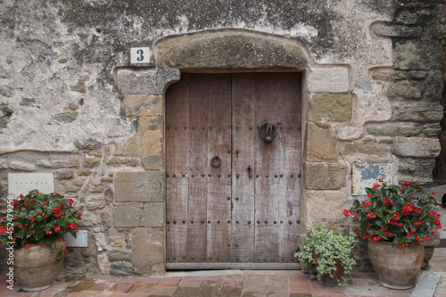 Beautiful view of an old wooden door in the building in the street of Monells, Gerona, Spain photo